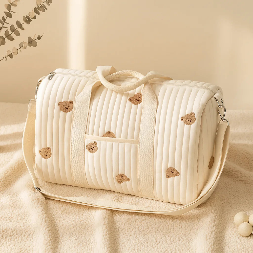 Sac à langer brodé animaux posé sur un plaid douillet, motifs oursons brodés
