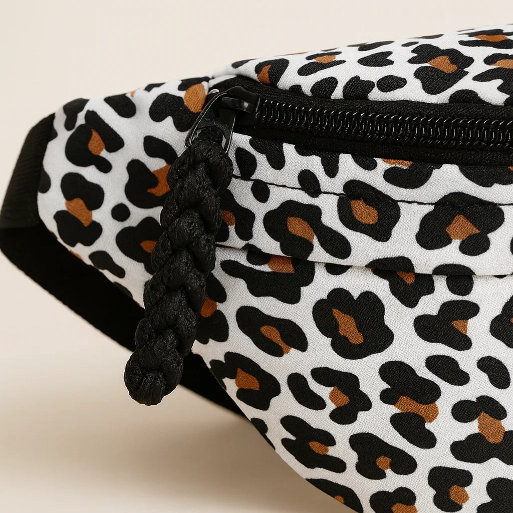 Détail du zip pompon tressé noir du sac banane léopard blanc | BebeSac